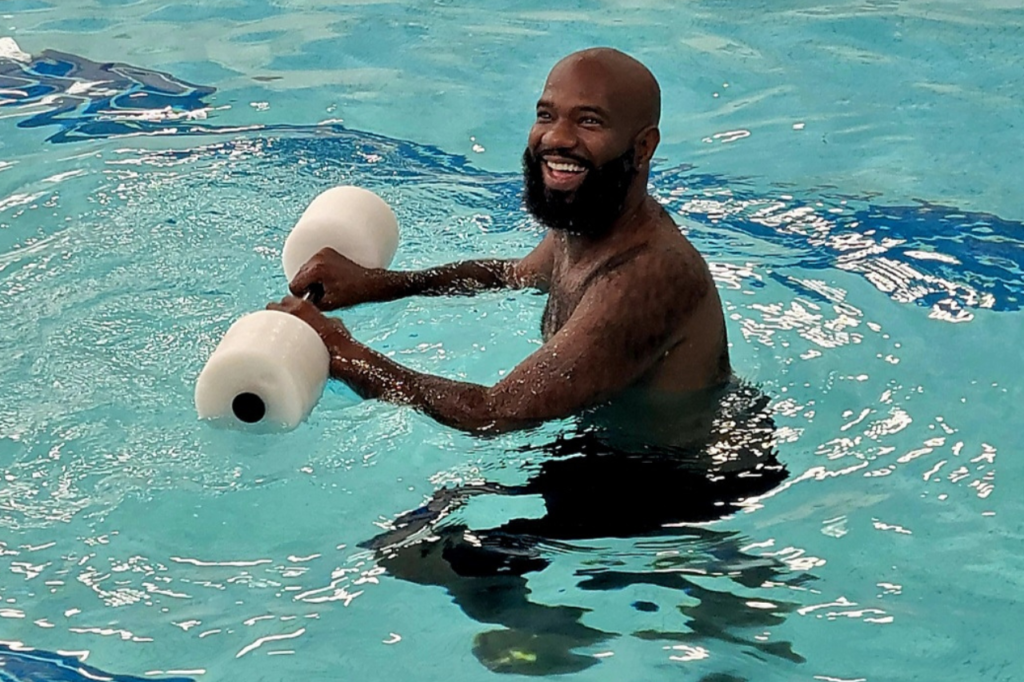 man learning to swim in pool