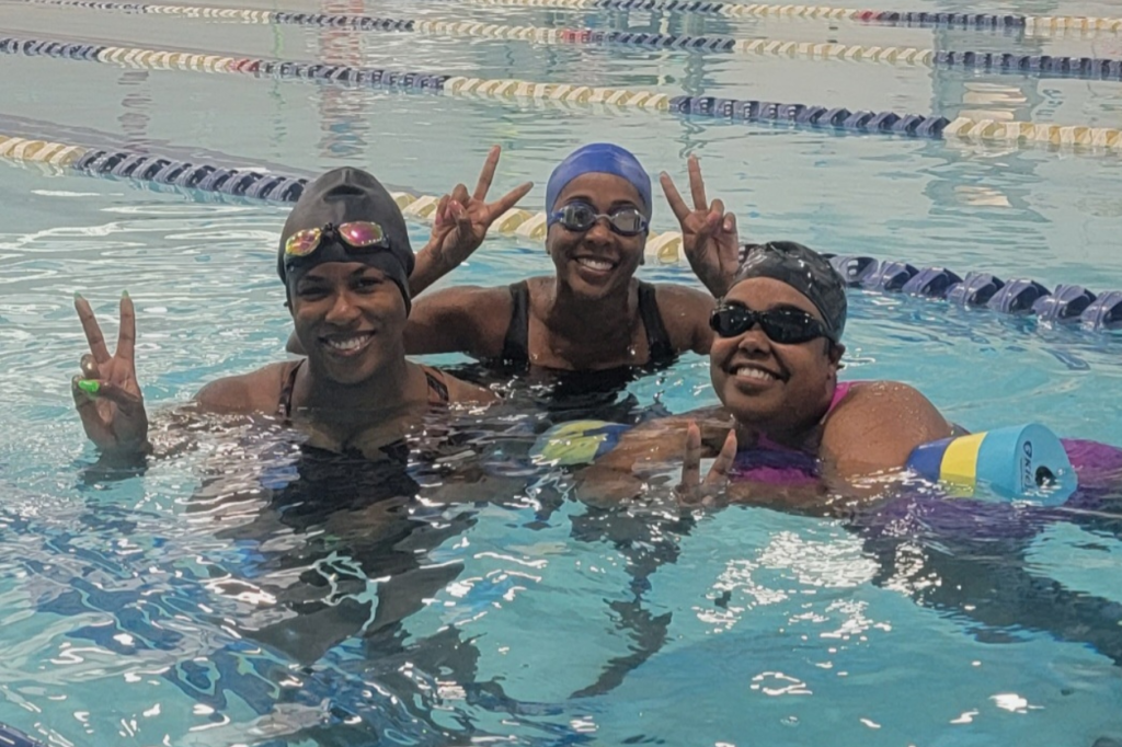 young women smiling for camera in pool